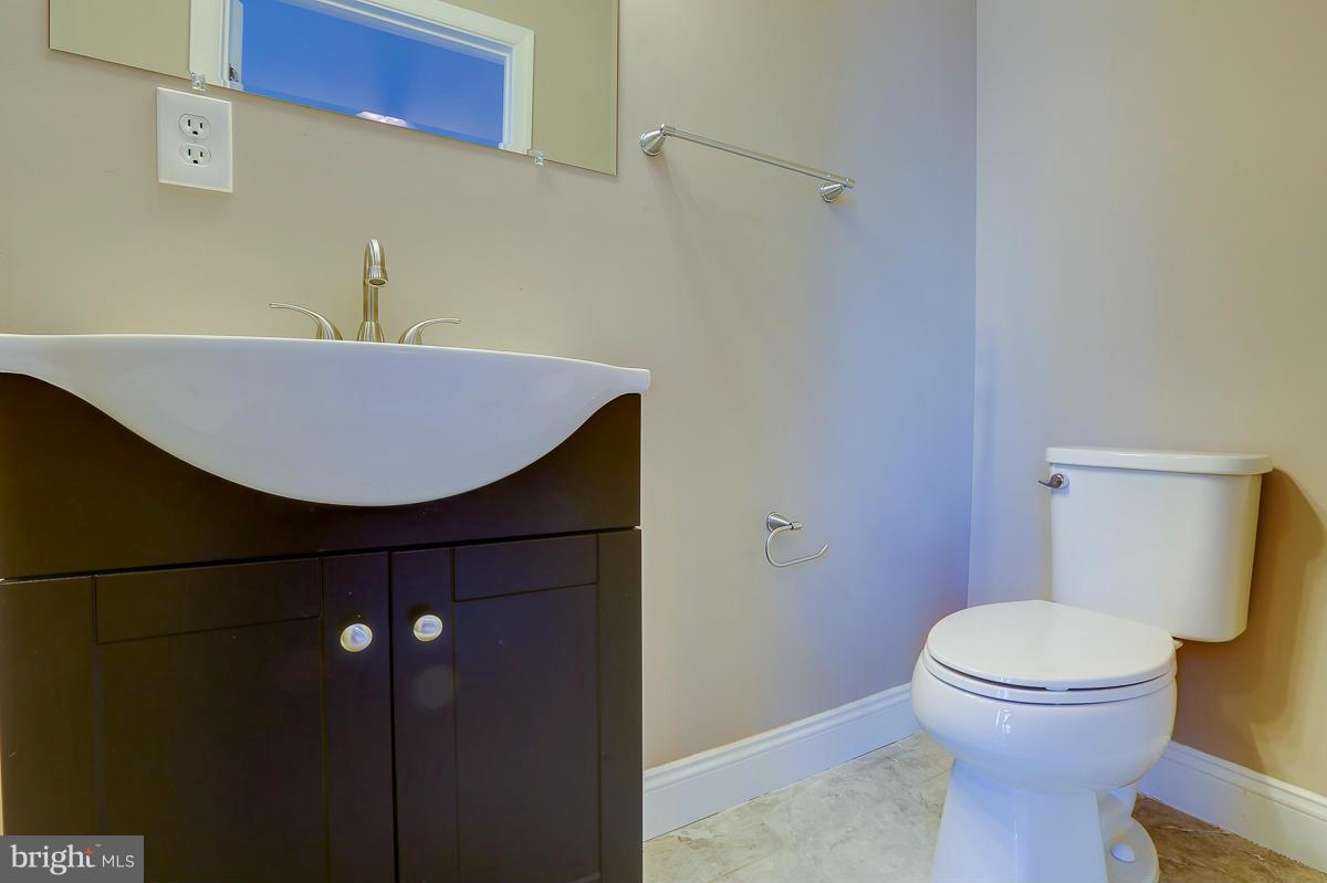 1533 Weyburn Road Baltimore, MD 21237 - Photo 20 of 30 a bathroom with a sink a toilet and a mirror