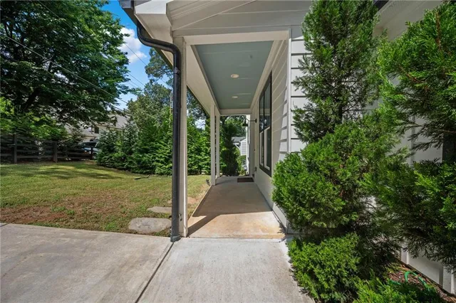 a view of a house with a yard and potted plants