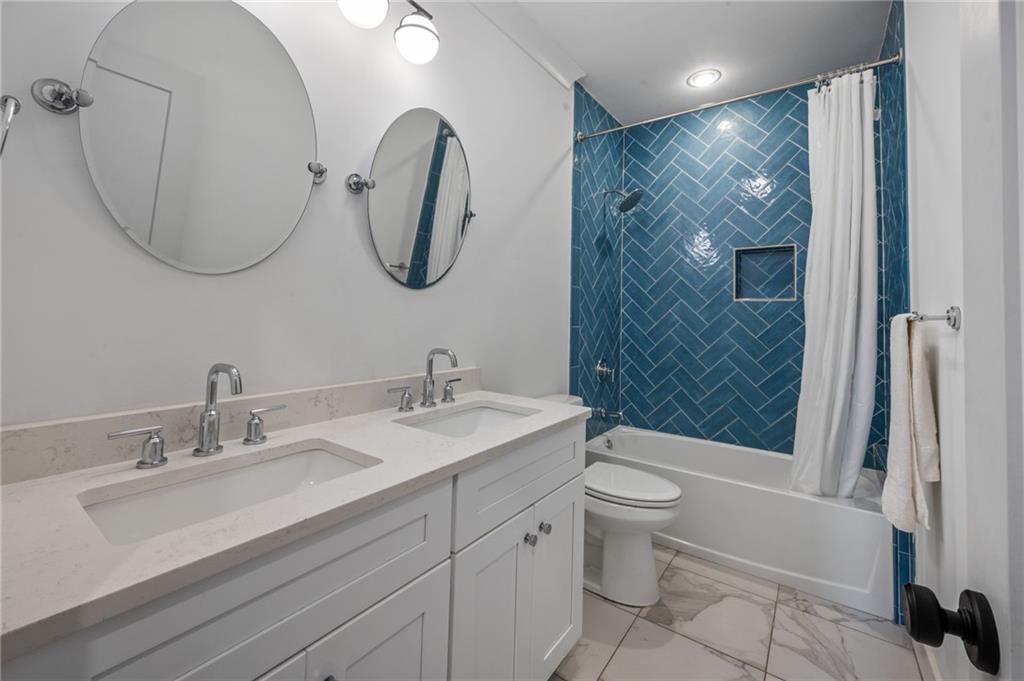 1058 Sanders Avenue Southeast Atlanta, GA 30316 - Photo 37 of 55 a bathroom with a double vanity sink toilet mirror and shower
