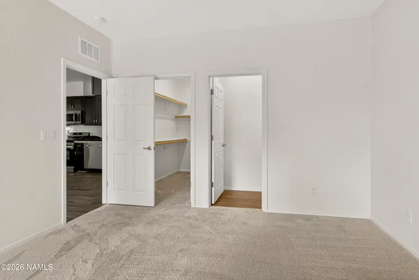 a view of empty room with kitchen