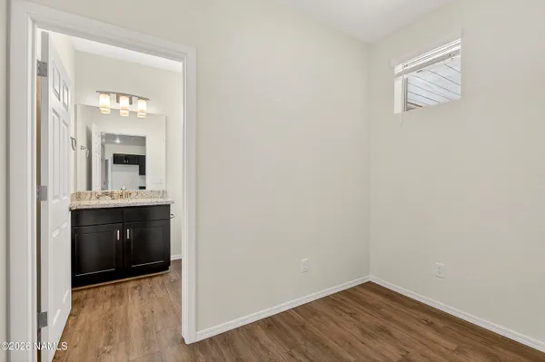 a view of a hallway and a kitchen with wooden floor