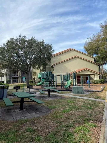 a backyard of a house with fountain table and chairs