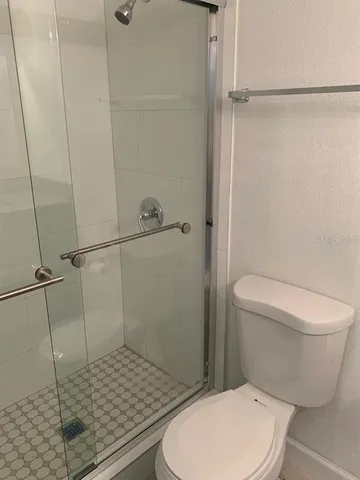 a bathroom with a toilet and a shower