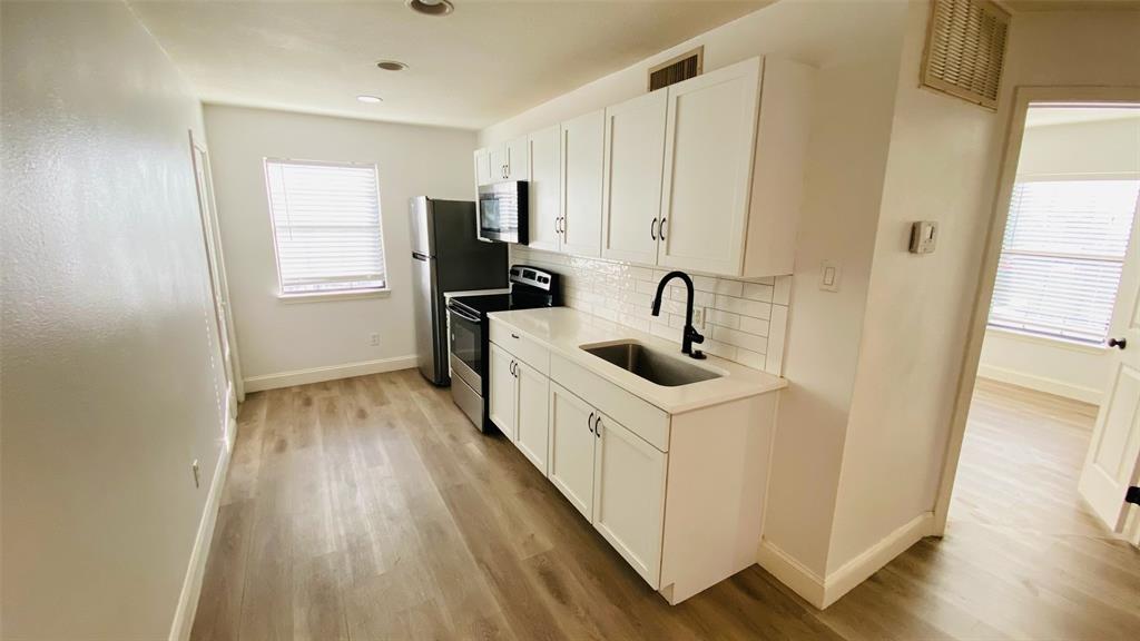 5003 Bryan Street, Unit 6 Dallas, TX 75206 - Photo 4 of 9 a kitchen with sink a refrigerator and wooden floor