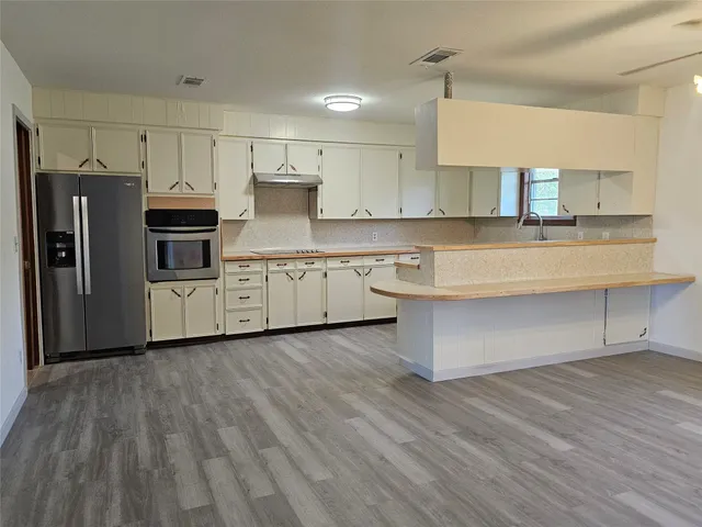 a kitchen with stainless steel appliances a refrigerator and a stove top oven