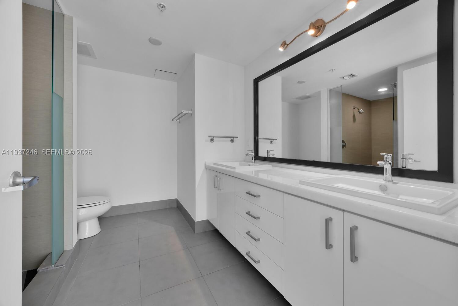 92 Southwest 3rd Street, Unit 3904 Miami, FL 33130 - Photo 13 of 23 a spacious bathroom with a granite countertop sink mirror and toilet