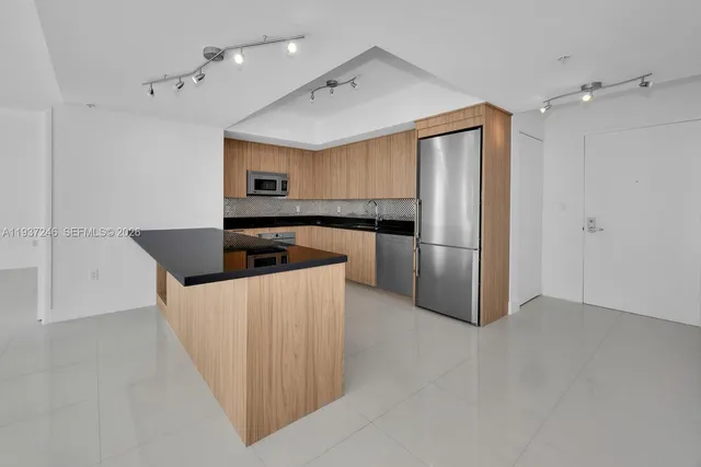 a kitchen with stainless steel appliances a refrigerator and a stove top oven