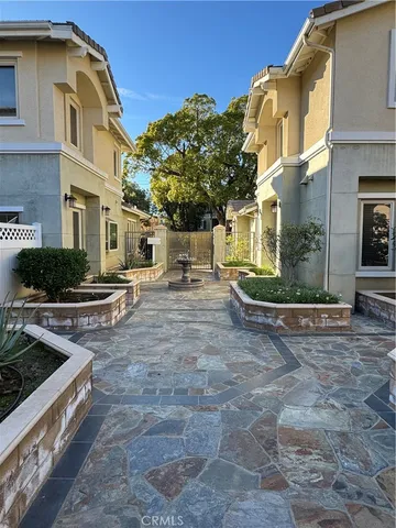 a view of a white building among the street with palm trees