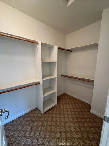 a room with walk in closet and bathroom