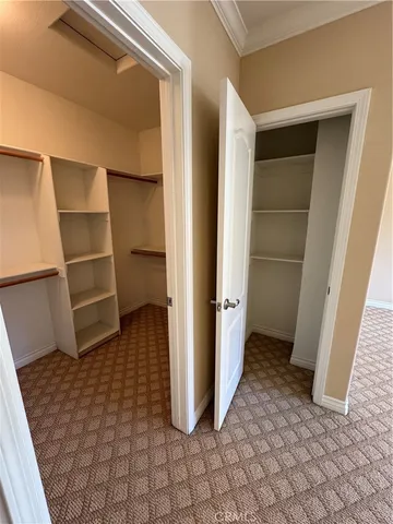 a view of walk in closet with empty racks