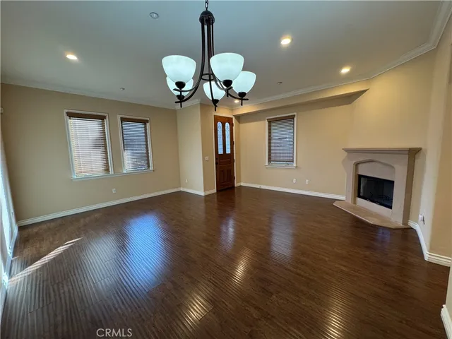 a view of a room with wooden floor and chandelier