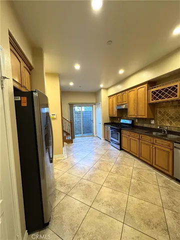 a kitchen with stainless steel appliances granite countertop a refrigerator and cabinets