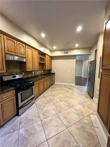 a kitchen with stainless steel appliances granite countertop a refrigerator and a stove top oven