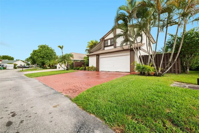 a view of a house with a big yard and large trees