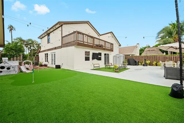 a view of a house with backyard and sitting area
