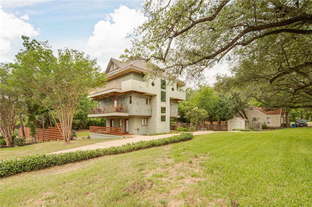 1015 East 24th Street Bryan, TX 77803 - Photo 2 of 43 a view of a white house with a big yard and large trees