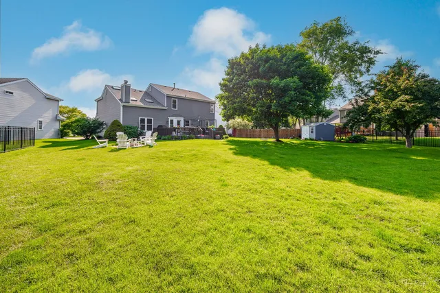 a view of a big house with a big yard and large trees