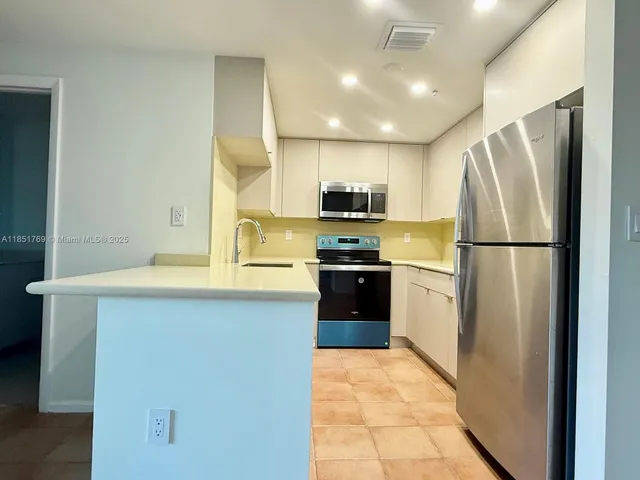 a kitchen with a refrigerator a sink and a microwave