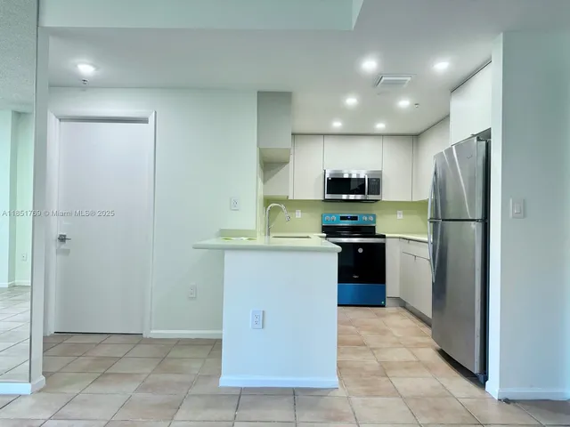 a kitchen with a refrigerator and a stove