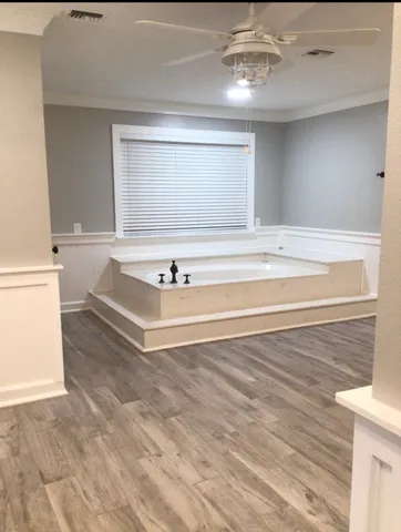 a bathroom with a bathtub and next to a window