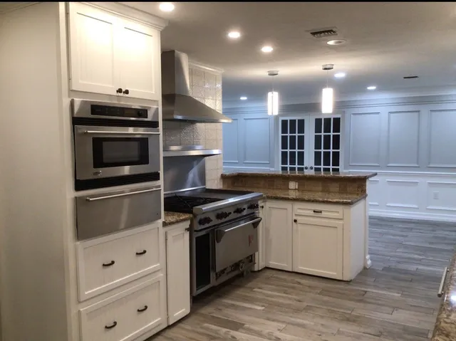 a kitchen with stainless steel appliances granite countertop a stove and a sink