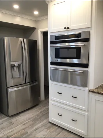 a metallic refrigerator freezer sitting inside of a kitchen