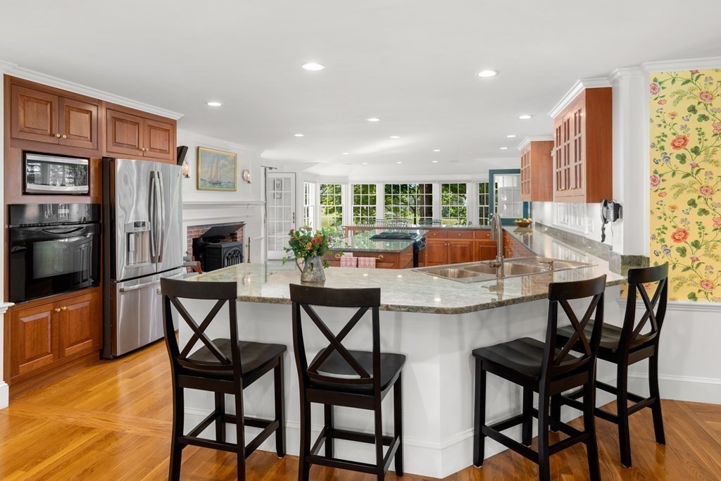 34 Sunset Road Duxbury, MA 02332 - Photo 11 of 42 a kitchen with stainless steel appliances kitchen island granite countertop a table and chairs