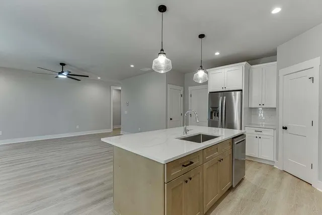 a kitchen with a sink chandelier and refrigerator