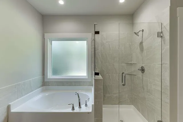 a white bath tub sitting next to a shower