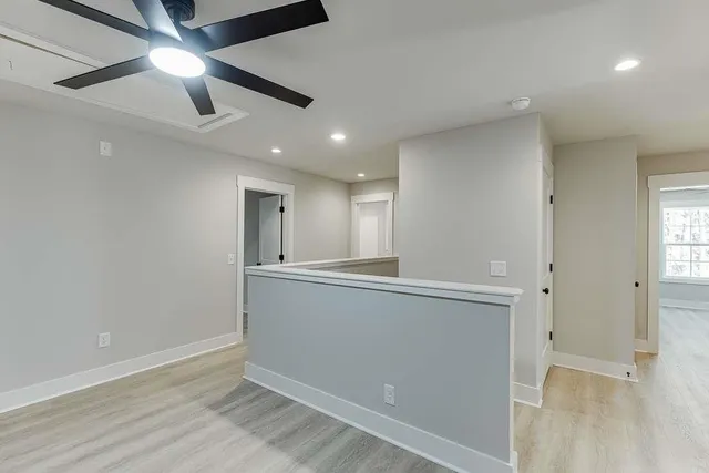 a view of an empty room with window and wooden floor