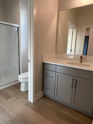 a bathroom with a sink a toilet and a large mirror