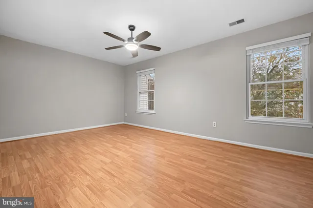 a view of empty room with wooden floor