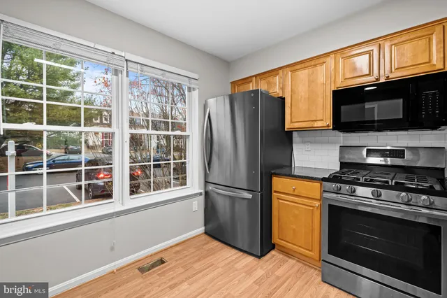a kitchen with stainless steel appliances granite countertop a refrigerator microwave and stove top oven