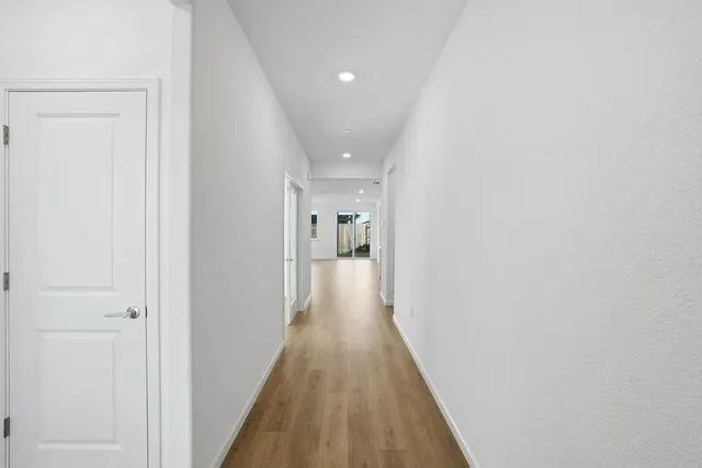 a view of a hallway with wooden floor