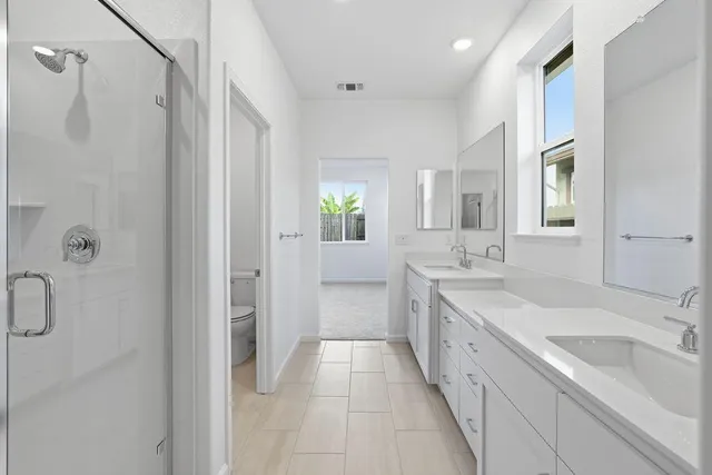a large bathroom with a double vanity sink a large mirror and a bathtub
