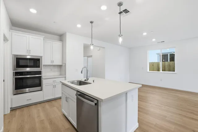 a kitchen that has a sink a stove and a microwave oven in it