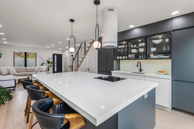 a kitchen with stainless steel appliances granite countertop a sink a stove and a wooden floors