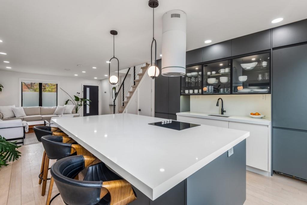 a kitchen with stainless steel appliances granite countertop a sink a stove and a wooden floors