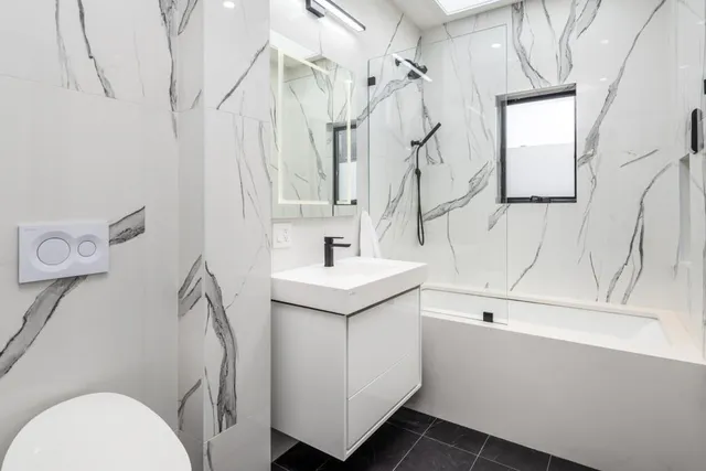 a bathroom with a sink mirror vanity and toilet