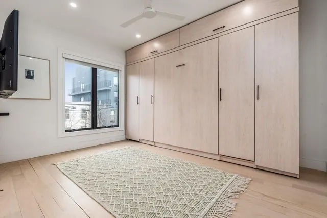 a view of an empty room with window and wooden floor