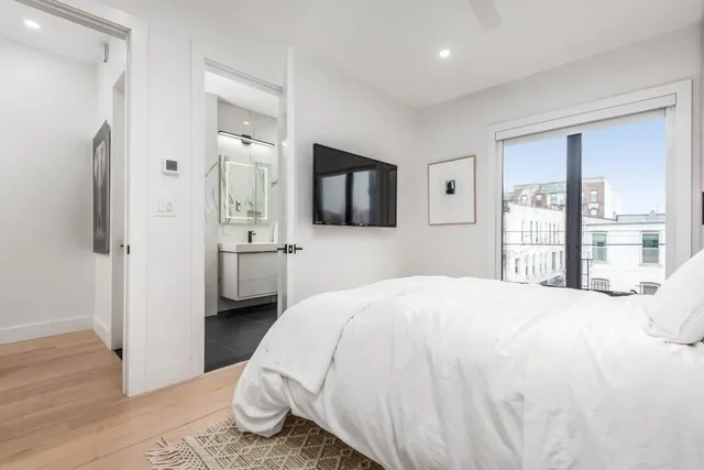 a bedroom with a bed and a large window