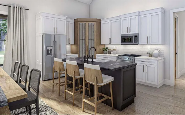 a kitchen with stainless steel appliances granite countertop a table chairs microwave and sink