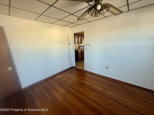 a view of a room with wooden floor and entryway