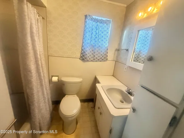 a white toilet sitting next to a small sink