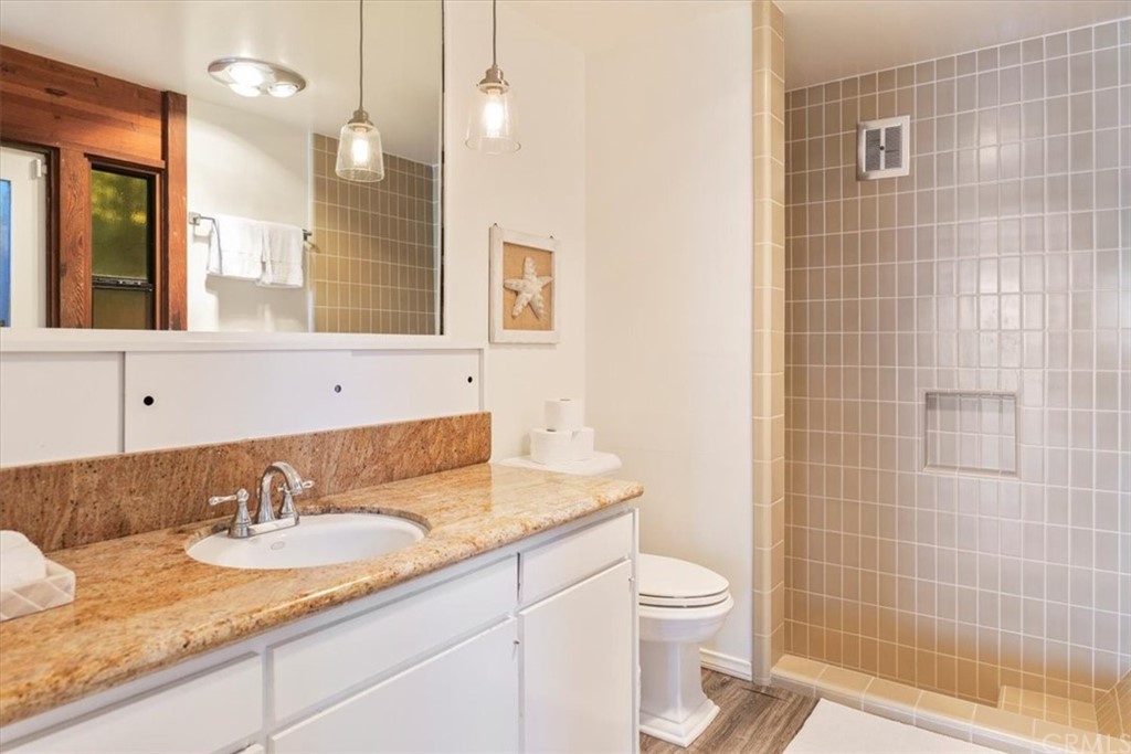 3036 Breakers Drive Corona del Mar, CA 92625 - Photo 44 of 48 a bathroom with a granite countertop sink a toilet and a mirror