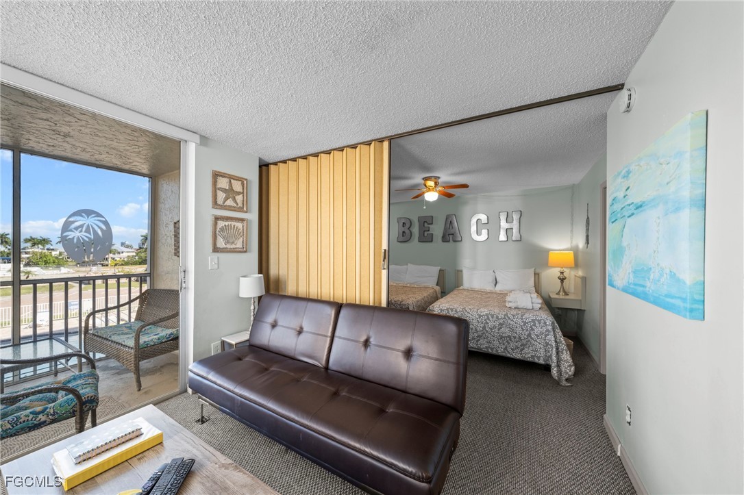 5600 Bonita Beach Road Southwest, Unit 204 Bonita Springs, FL 34134 - Photo 5 of 23 a living room with furniture and a lamp