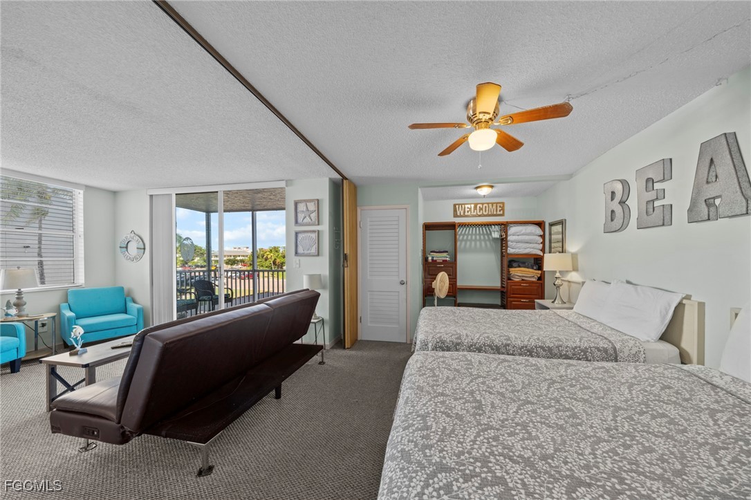 5600 Bonita Beach Road Southwest, Unit 204 Bonita Springs, FL 34134 - Photo 6 of 23 a bedroom with a bed a couch and dresser with wooden floor