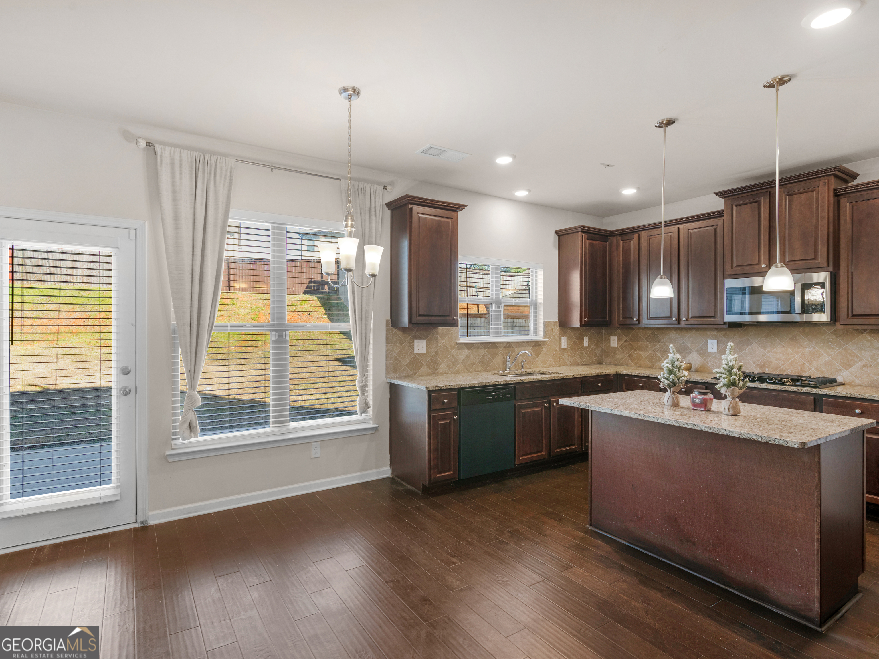 630 Oakville Trail Hampton, GA 30228 - Photo 9 of 36 a kitchen with kitchen island granite countertop a stove a sink a center island and wooden floor