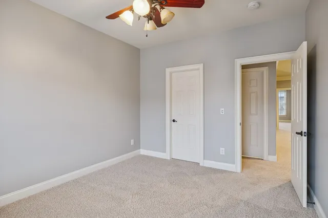 an empty room with a chandelier fan