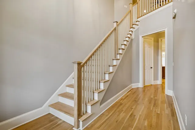 a view of staircase with wooden floor and white walls